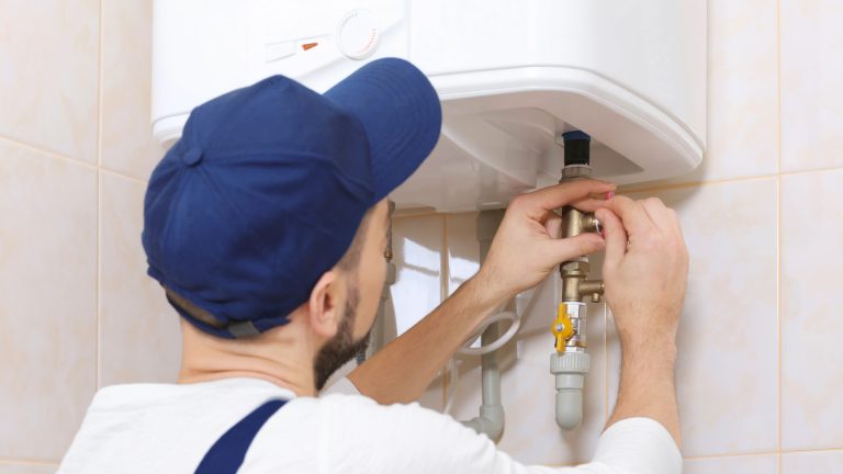 Plumber checking a water heater connection when there is no hot water in house fixtures
