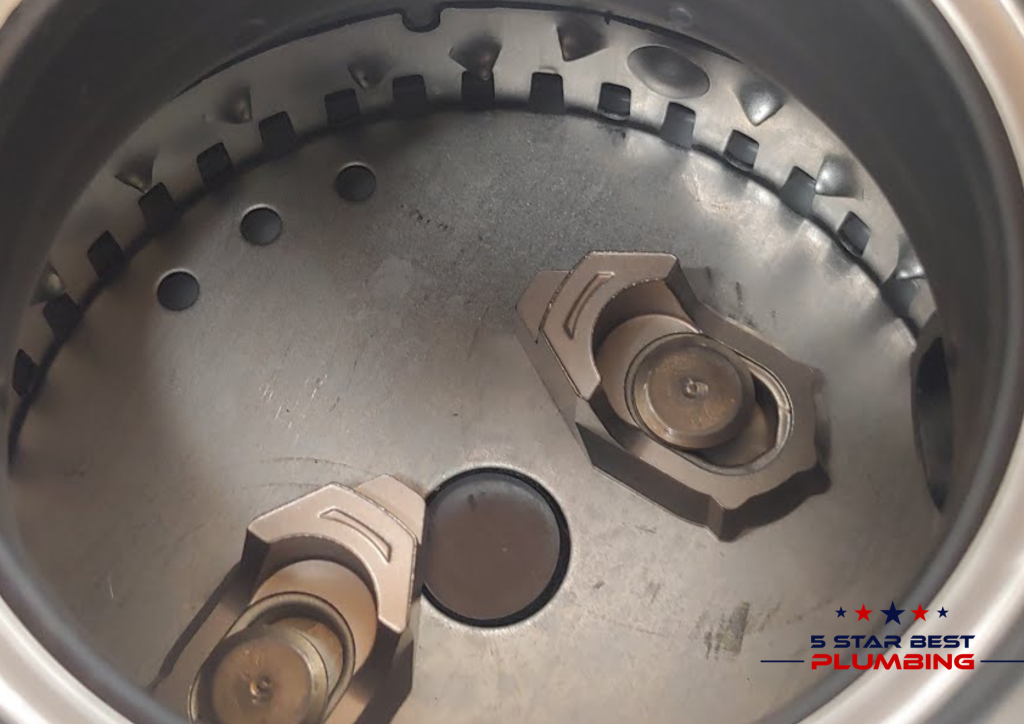 Inside view of jammed garbage disposal showing stuck impeller and food debris causing blockage