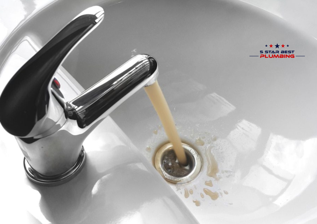 Discolored, rusty brown water flowing from a chrome faucet into a white ceramic bathroom sink, illustrating common water heater or piping issues.